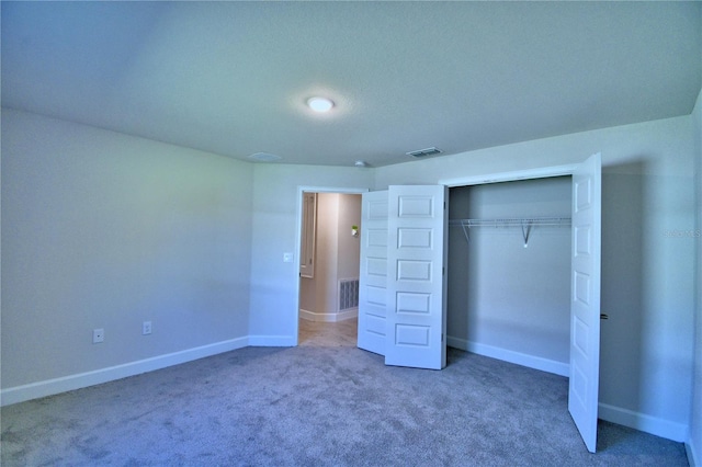 unfurnished bedroom featuring baseboards, carpet floors, visible vents, and a closet