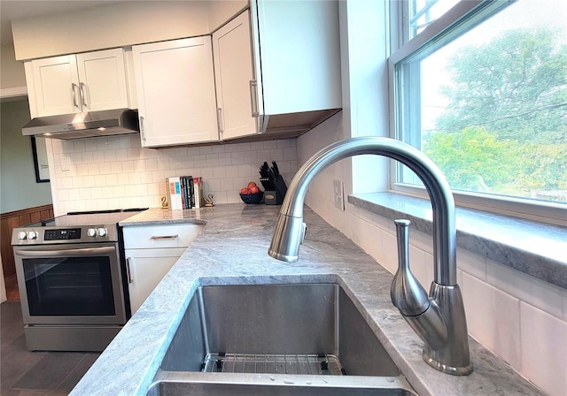 2816 Fairmount Ave, Lakeland, FL 33803 - kitchen with electric stove, exhaust hood, and white cabinetry