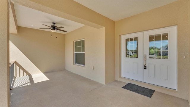 property entrance featuring ceiling fan, a patio, stucco siding, and french doors
