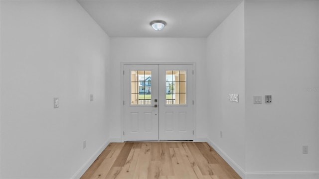 doorway featuring light wood-type flooring and baseboards