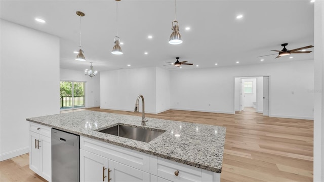 kitchen featuring dishwasher, ceiling fan with notable chandelier, open floor plan, and a sink