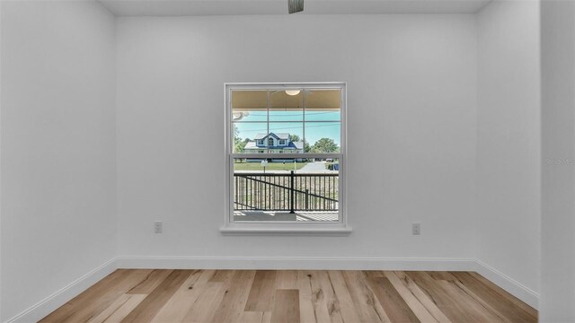 empty room featuring baseboards and light wood finished floors