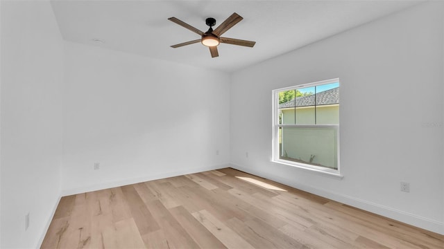 empty room featuring ceiling fan, baseboards, and wood finished floors