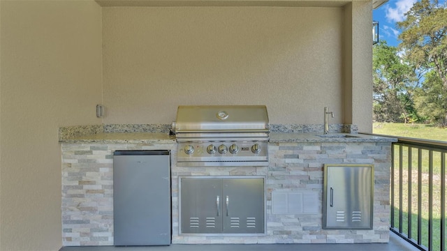 view of patio / terrace with a sink, area for grilling, and an outdoor kitchen