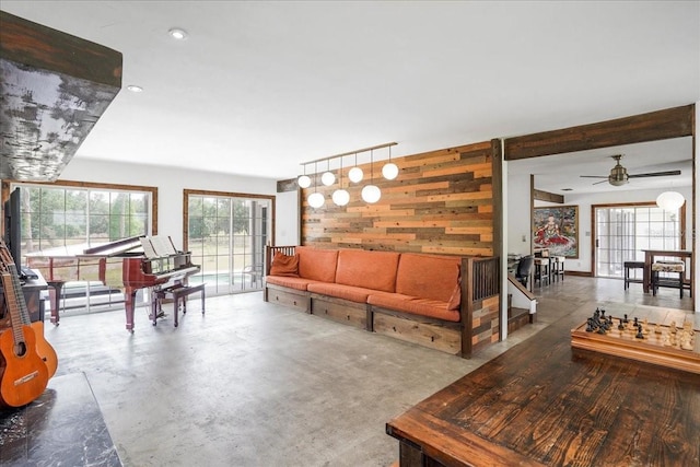 8922 Pritcher Rd, Lithia, FL 33547 - living room featuring wood walls, a ceiling fan, and concrete floors