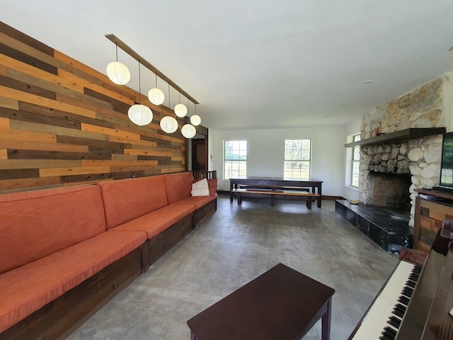 8922 Pritcher Rd, Lithia, FL 33547 - living room with finished concrete flooring, wooden walls, and a stone fireplace