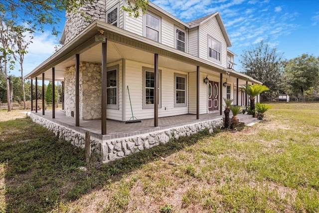 8922 Pritcher Rd, Lithia, FL 33547 - view of front of house with covered porch, stone siding, and a front lawn