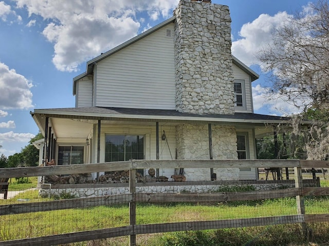 8922 Pritcher Rd, Lithia, FL 33547 - view of front of home with a chimney, covered porch, stone siding, and roof with shingles