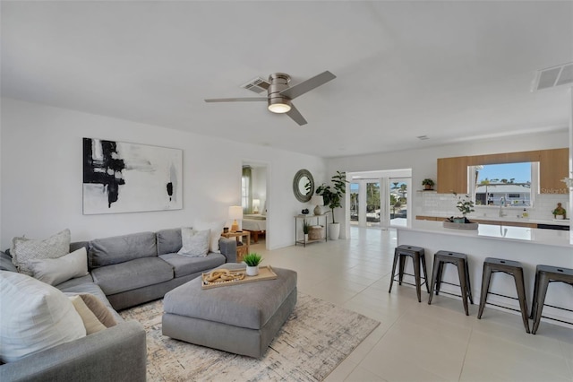 living area featuring ceiling fan, light tile patterned floors, visible vents, and french doors