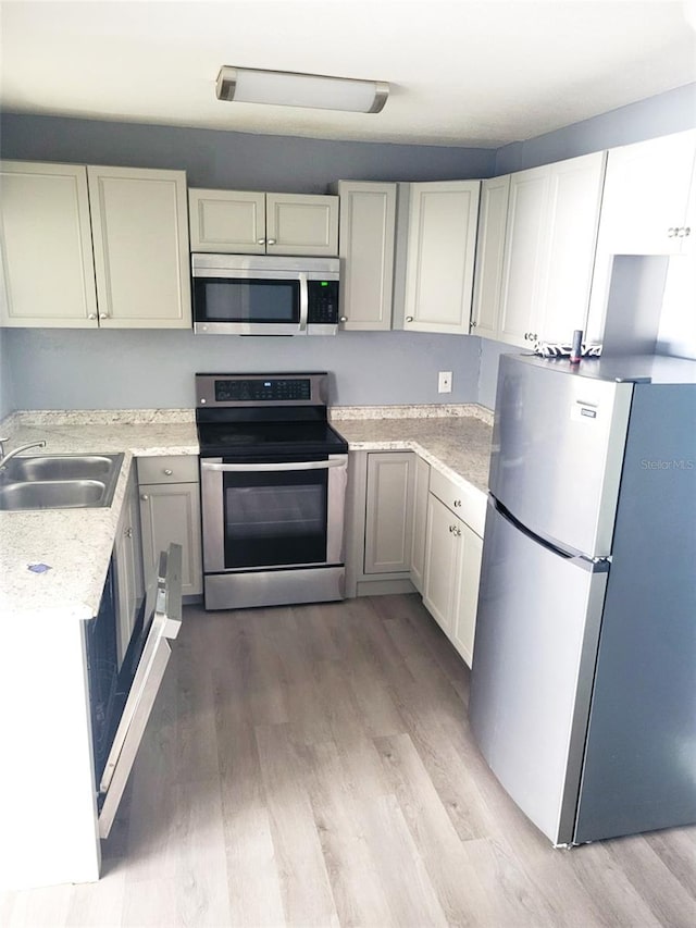 1024 31st St NW, Winter Haven, FL 33881 - kitchen with stainless steel appliances, light countertops, and light wood-type flooring