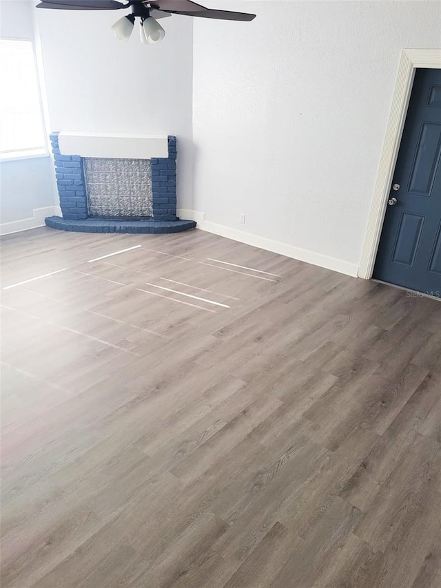 1024 31st St NW, Winter Haven, FL 33881 - unfurnished living room with wood finished floors, a ceiling fan, and a fireplace