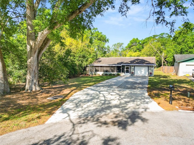 single story home featuring a front lawn, driveway, and a garage