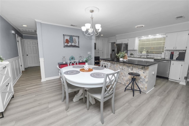 dining area featuring visible vents, ornamental molding, and a notable chandelier