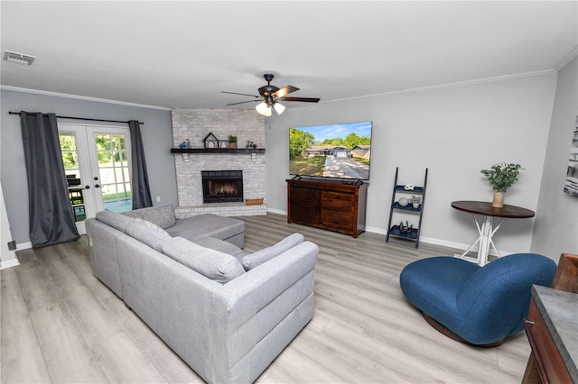 living area featuring crown molding, light wood-style floors, ceiling fan, baseboards, and visible vents