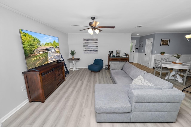living room with a ceiling fan, crown molding, visible vents, and light wood-style flooring