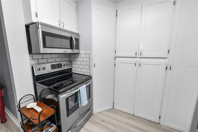 kitchen featuring white cabinets, light wood-style flooring, and appliances with stainless steel finishes
