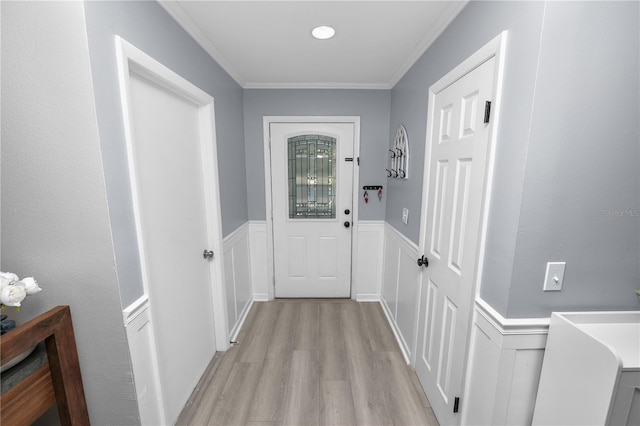 entryway featuring wainscoting, light wood-style flooring, and crown molding
