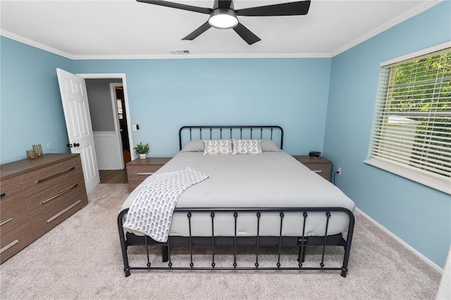 carpeted bedroom with visible vents, crown molding, baseboards, and a ceiling fan