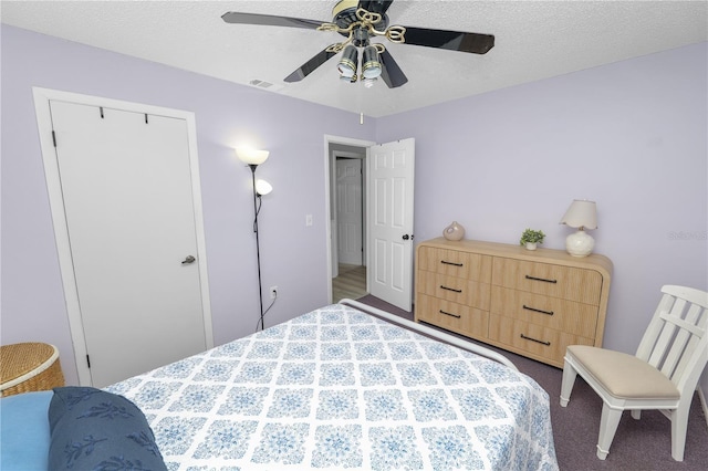 bedroom featuring a ceiling fan, visible vents, and dark carpet