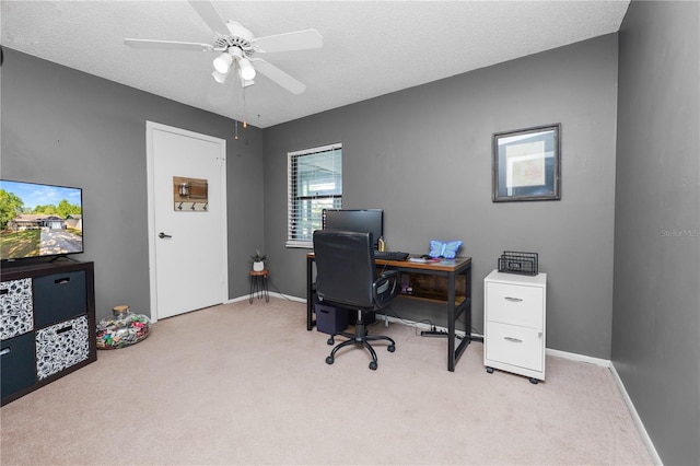 carpeted home office featuring a ceiling fan and baseboards