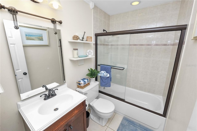 full bath with combined bath / shower with glass door, tile patterned floors, vanity, and toilet