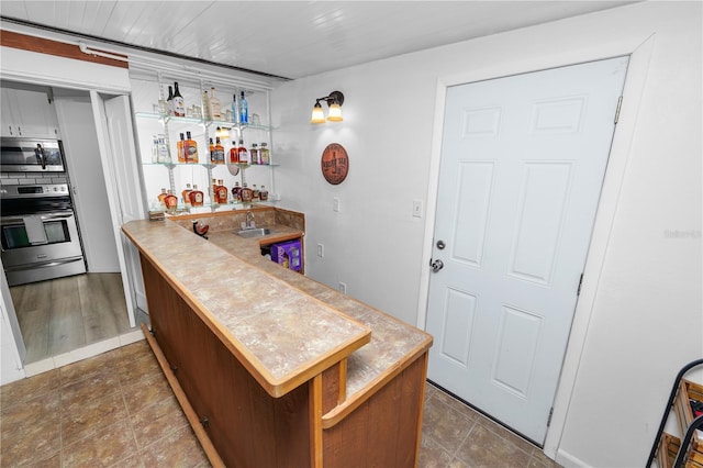 bar with indoor wet bar, stainless steel appliances, and a sink