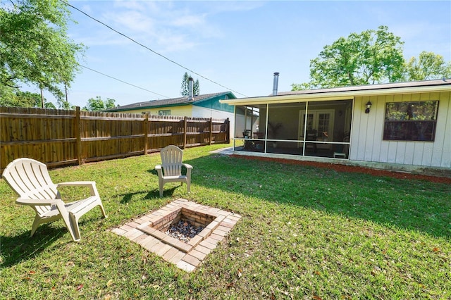 view of yard with an outdoor fire pit, fence private yard, and a sunroom