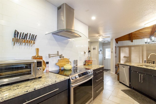 kitchen featuring ceiling fan, tasteful backsplash, appliances with stainless steel finishes, a sink, and extractor fan