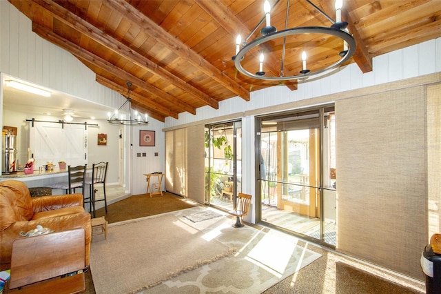 interior space with a notable chandelier, lofted ceiling with beams, a barn door, and wood ceiling