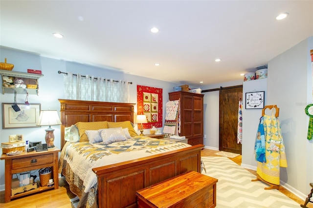 bedroom featuring baseboards, a barn door, recessed lighting, and light wood-type flooring