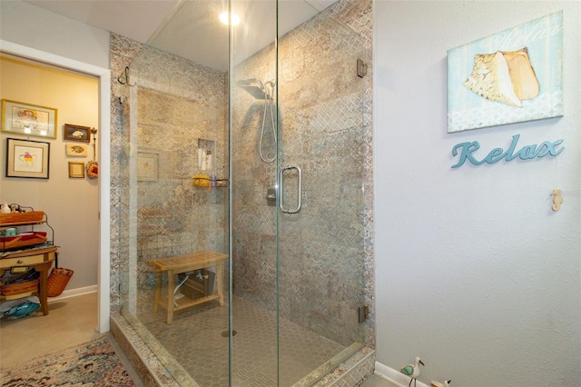bathroom featuring baseboards and a shower stall