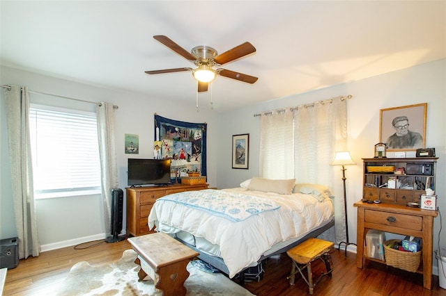 bedroom with a ceiling fan, baseboards, and wood finished floors