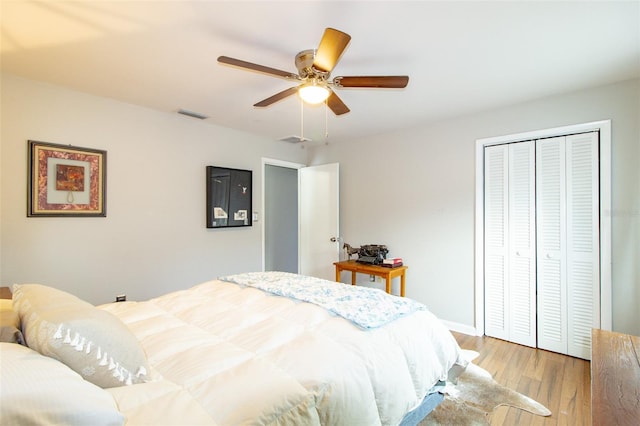 bedroom featuring a ceiling fan, a closet, light wood-style floors, and visible vents