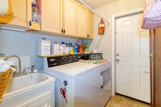 washroom with a sink, cabinet space, and washer and dryer