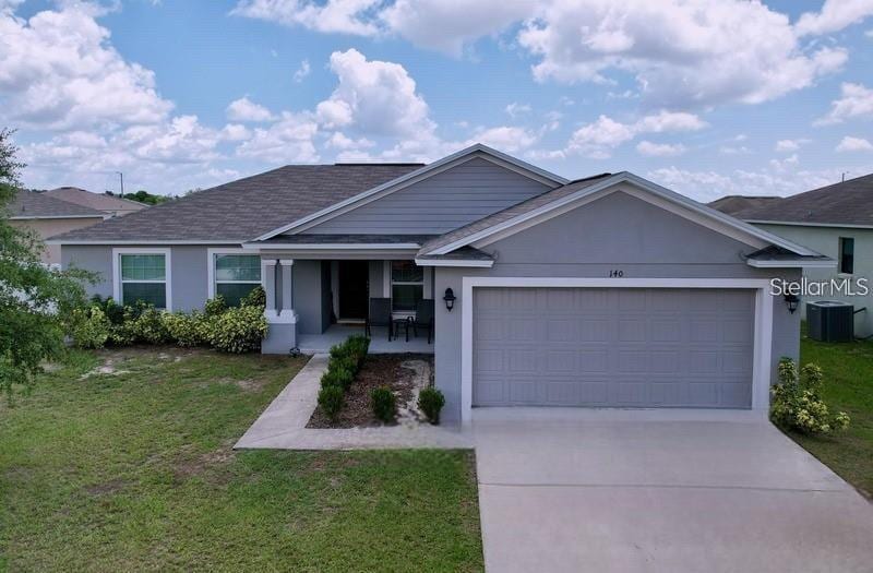 140 Solis Dr, Winter Haven, FL 33880 - single story home with concrete driveway, stucco siding, roof with shingles, an attached garage, and a front lawn