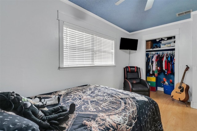 202 Saint Lucie Rd, Winter Haven, FL 33884 - bedroom with wood finished floors, ornamental molding, a closet, and a ceiling fan