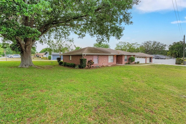 202 Saint Lucie Rd, Winter Haven, FL 33884 - view of front facade featuring a front yard, brick siding, and an attached garage
