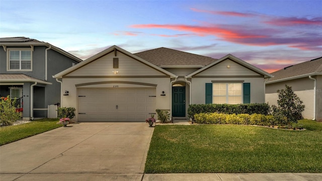 view of front of house featuring stucco siding, driveway, an attached garage, and a yard