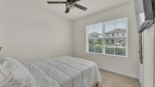 bedroom featuring baseboards, ceiling fan, and light colored carpet