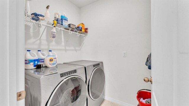 laundry area with washer and clothes dryer, laundry area, and baseboards