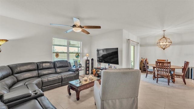 living room with ceiling fan with notable chandelier and light tile patterned floors