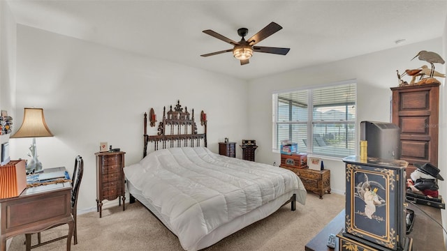bedroom featuring a ceiling fan, light carpet, and baseboards