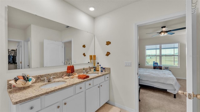 bathroom featuring baseboards, double vanity, and a sink