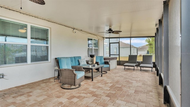 sunroom featuring a jacuzzi, brick floor, and ceiling fan