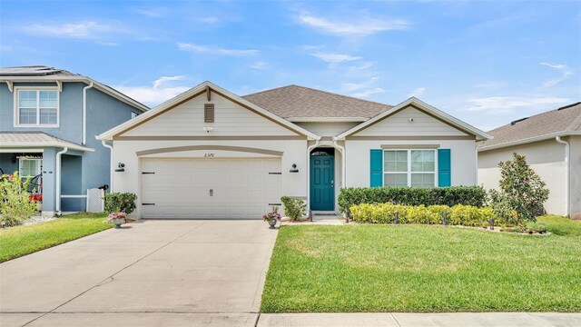 ranch-style house featuring a front yard, driveway, stucco siding, and an attached garage
