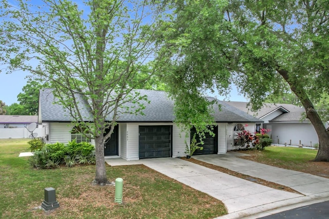 2042 Windward Pass, Lakeland, FL 33813 - view of front facade featuring a front lawn, a shingled roof, a garage, and concrete driveway