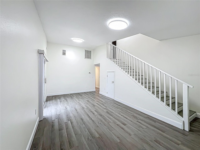 2042 Windward Pass, Lakeland, FL 33813 - unfurnished living room featuring stairs, visible vents, wood finished floors, and baseboards
