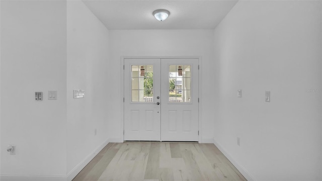 doorway to outside with light wood finished floors, baseboards, and french doors
