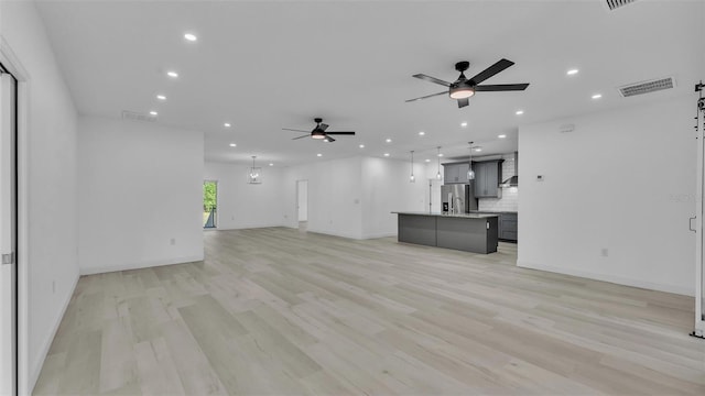 unfurnished living room with ceiling fan, recessed lighting, and visible vents