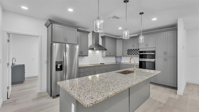 kitchen featuring a sink, black electric cooktop, gray cabinetry, and stainless steel fridge